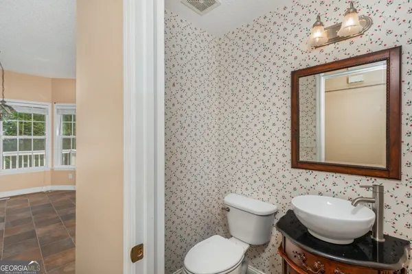a bathroom with a toilet sink and mirror