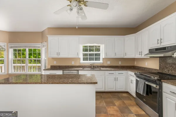 a kitchen with stainless steel appliances granite countertop a stove a sink and a microwave