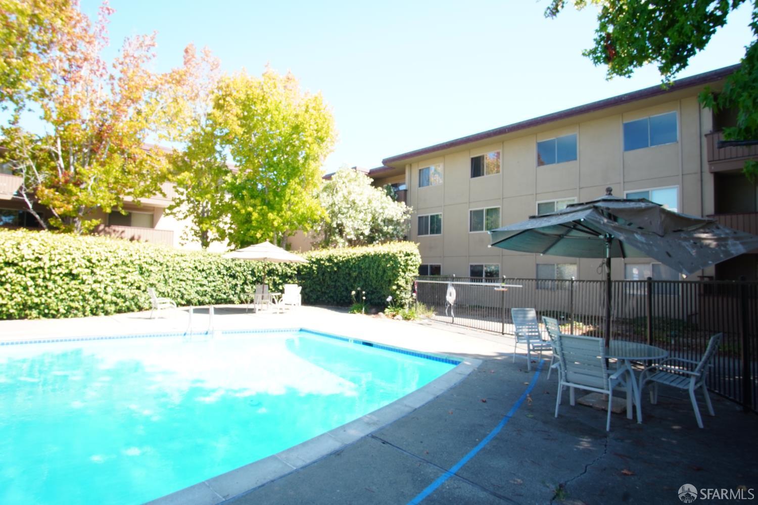 1305 Webster Street, Unit C309 Alameda, CA 94501 - Photo 19 of 24 a view of a patio with a table and chairs under an umbrella