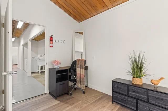 a view of a workspace with furniture and wooden floor