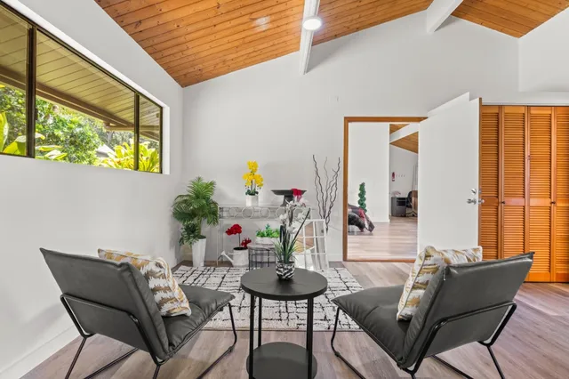a dining room with furniture and a potted plant