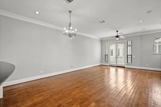 a view of an empty room with window and wooden floor