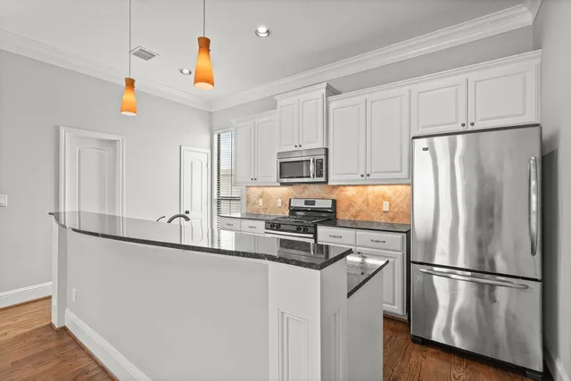 a kitchen with stainless steel appliances a refrigerator a stove a microwave and cabinets