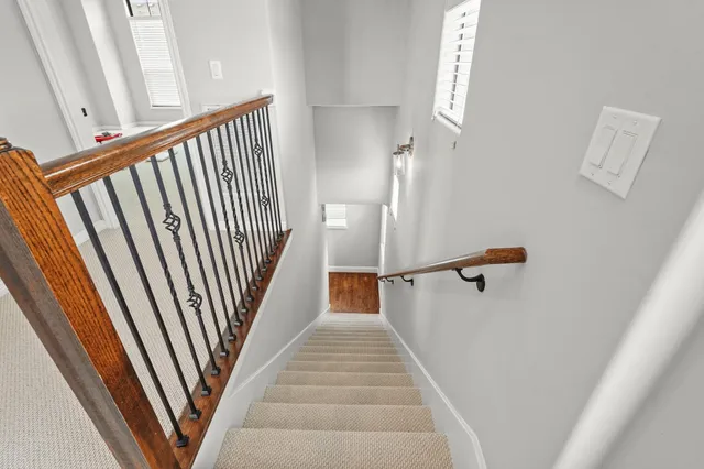 a view of a hallway with wooden floor and staircase