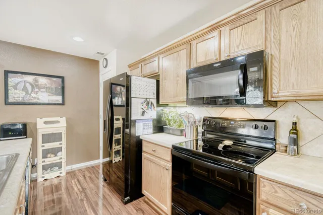 a kitchen with stainless steel appliances a stove microwave and sink