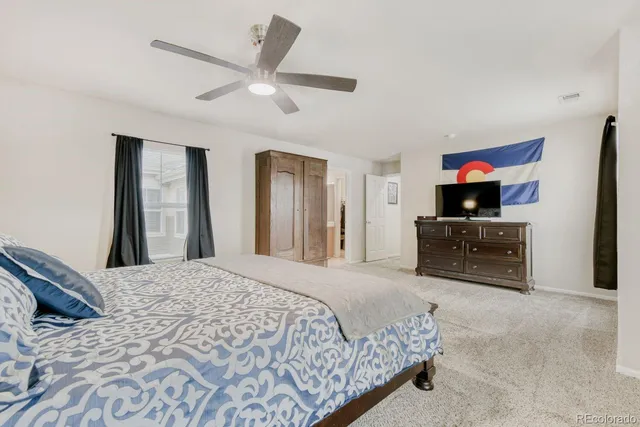 a spacious bedroom with a balcony a bed and a chandelier