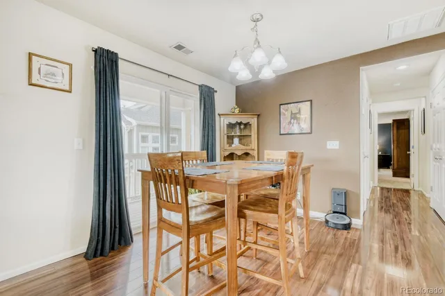 a dining room with furniture a chandelier and wooden floor