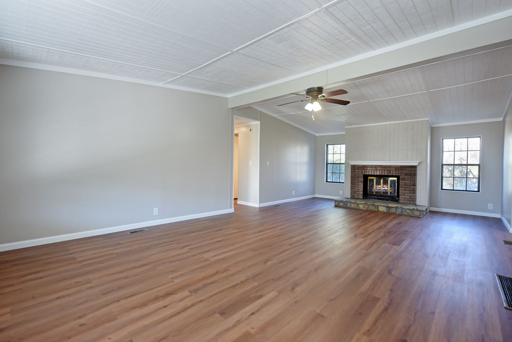 253 Windy Lane Hiawassee, GA 30546 - Photo 22 of 65 an empty room with wooden floor and fireplace