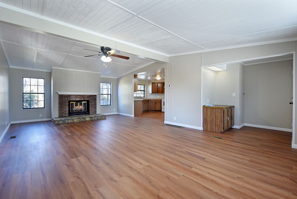 253 Windy Lane Hiawassee, GA 30546 - Photo 23 of 65 an empty room with wooden floor fireplace and windows