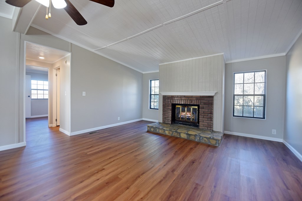 253 Windy Lane Hiawassee, GA 30546 - Photo 29 of 65 an empty room with wooden floor fireplace and windows