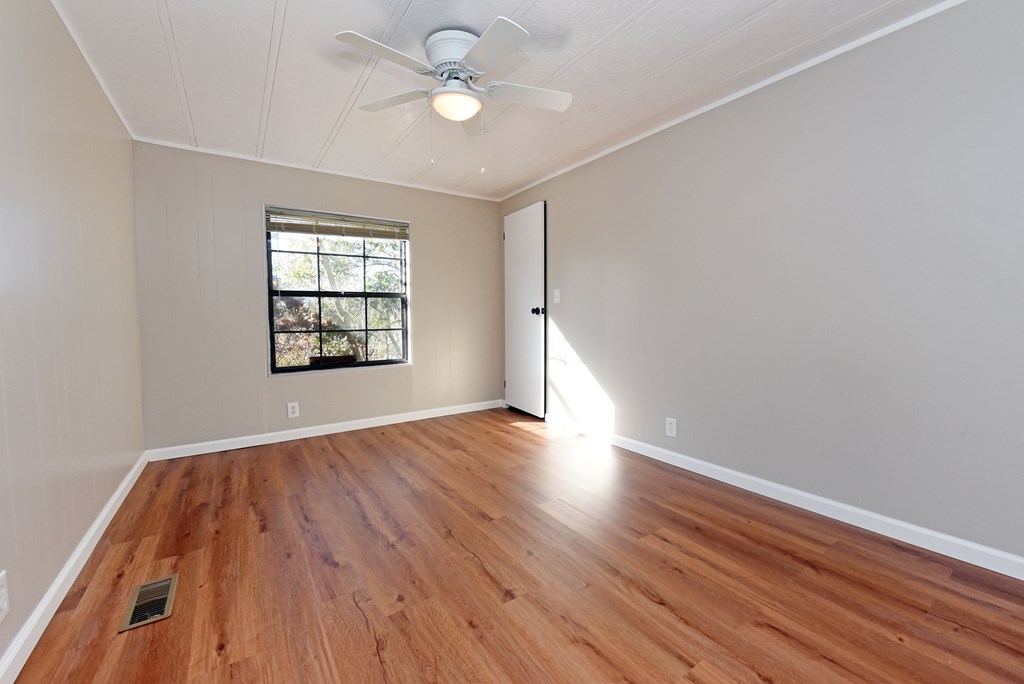 253 Windy Lane Hiawassee, GA 30546 - Photo 34 of 65 an empty room with wooden floor chandelier fan and windows