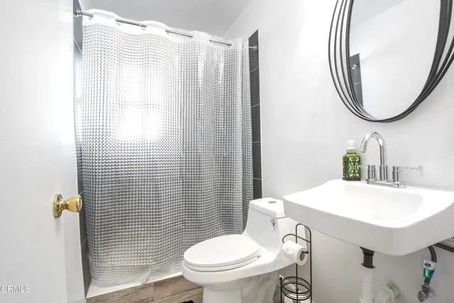 a bathroom with a sink a toilet and a mirror