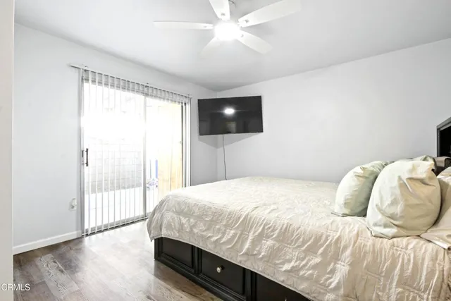 a bedroom with a bed a flat screen tv and a large window