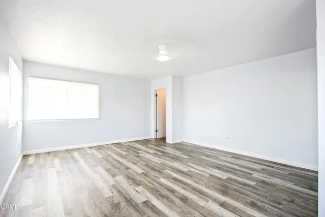a view of an empty room with wooden floor