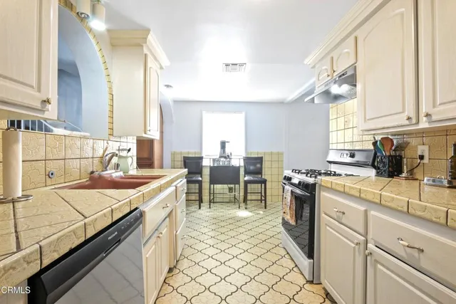 a kitchen with a sink stove and cabinets