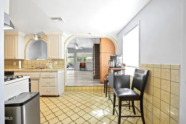 a living room with granite countertop furniture a fireplace and kitchen view