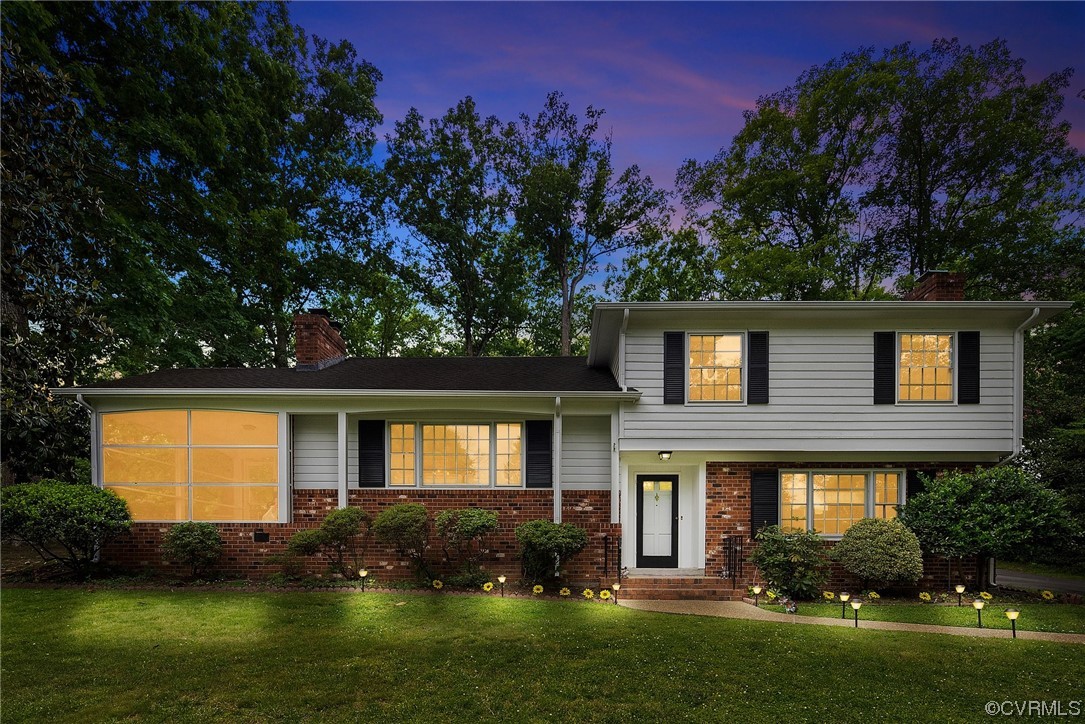 a front view of a house with a garden and yard