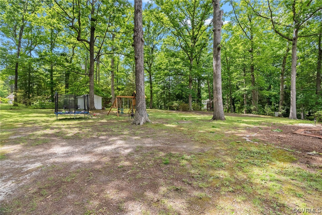 5038 Grassmere Road Richmond, VA 23234 - Photo 48 of 50 a backyard of a house with lots of green space and fountain