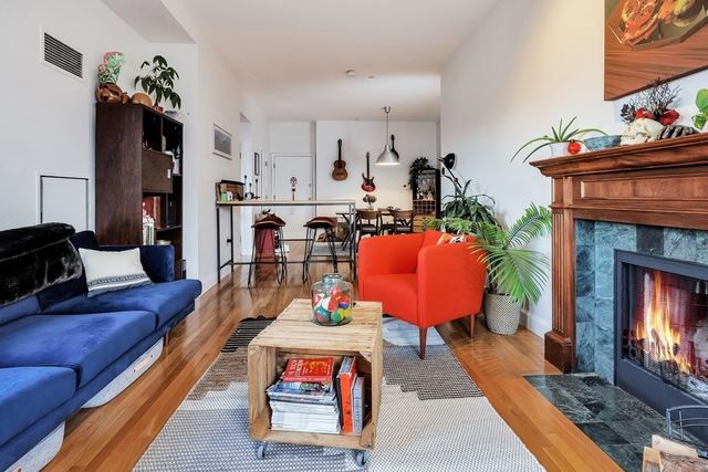 a living room with furniture a fireplace and a potted plant
