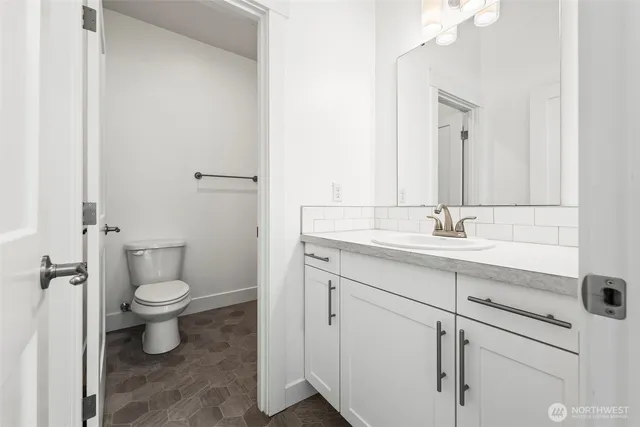 a bathroom with a toilet sink and mirror