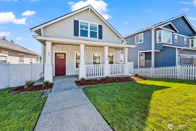 a view of a house with a small yard and wooden fence