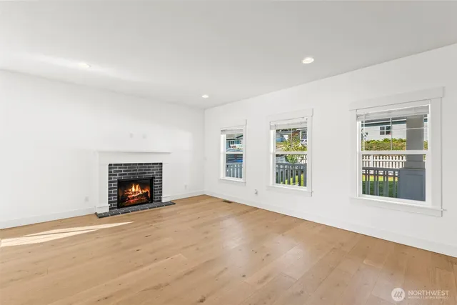 an empty room with windows and fireplace