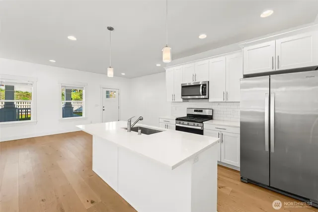 a kitchen with stainless steel appliances a refrigerator stove microwave and sink