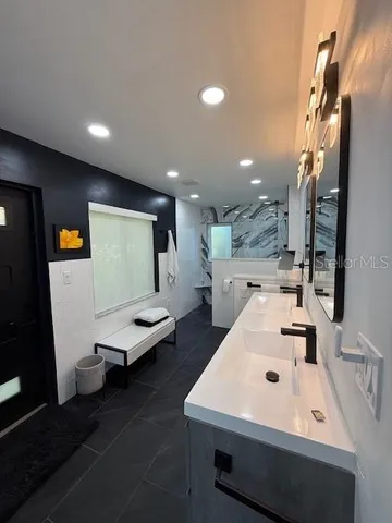 a bathroom with a sink a toilet and a mirror