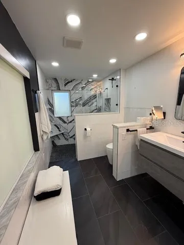 a bathroom with a sink a toilet and a mirror