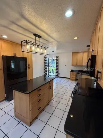a kitchen with granite countertop a sink and a stove top oven
