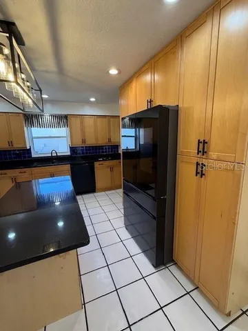 a large kitchen with stainless steel appliances kitchen island granite countertop a sink and cabinets
