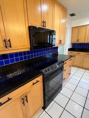 a kitchen with stainless steel appliances a sink a stove a microwave a counter top space and cabinets