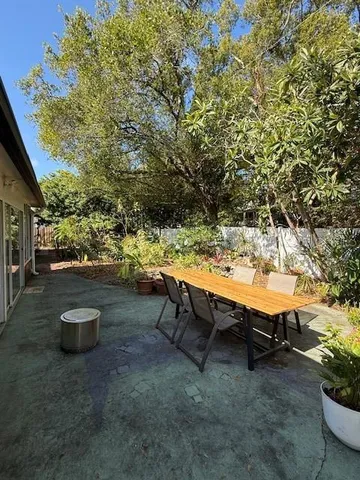 a view of a backyard with lawn chairs and a fire pit