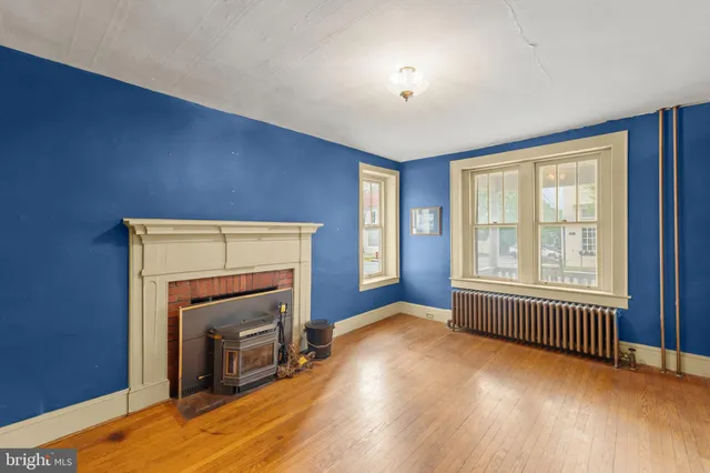 a view of an empty room with a fireplace and a window