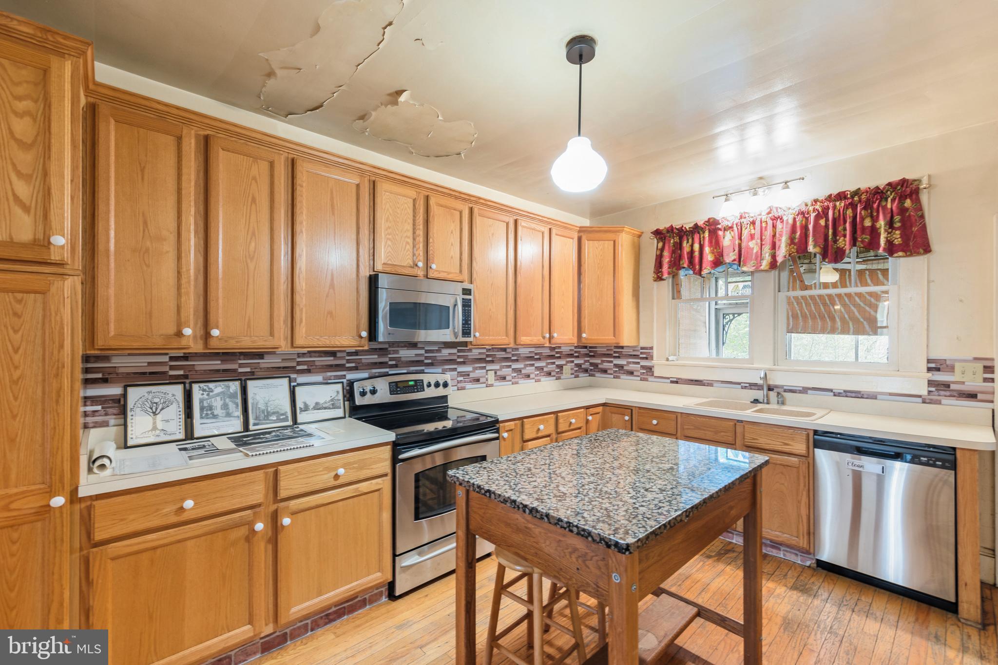 5342 Main Street Stephens City, VA 22655 - Photo 8 of 45 a kitchen with stainless steel appliances granite countertop a stove a sink dishwasher and a refrigerator with wooden floor