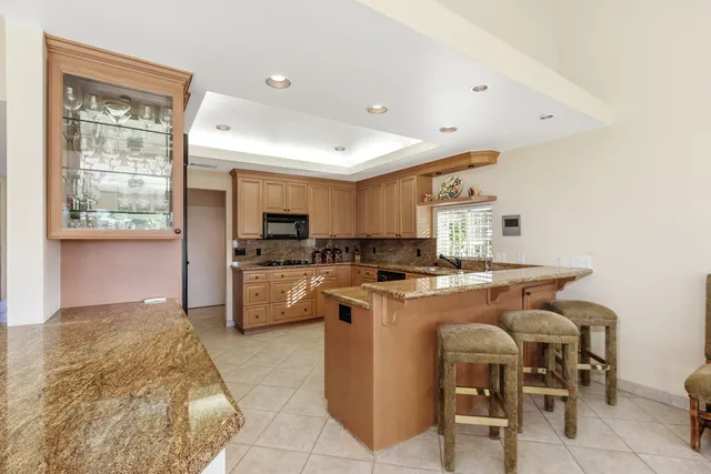 a kitchen with stainless steel appliances granite countertop a refrigerator a stove top oven a sink and dishwasher
