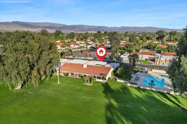 a view of swimming pool with outdoor seating and palm trees
