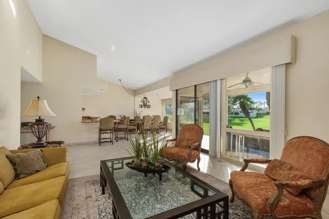 a living room with patio furniture and a floor to ceiling window