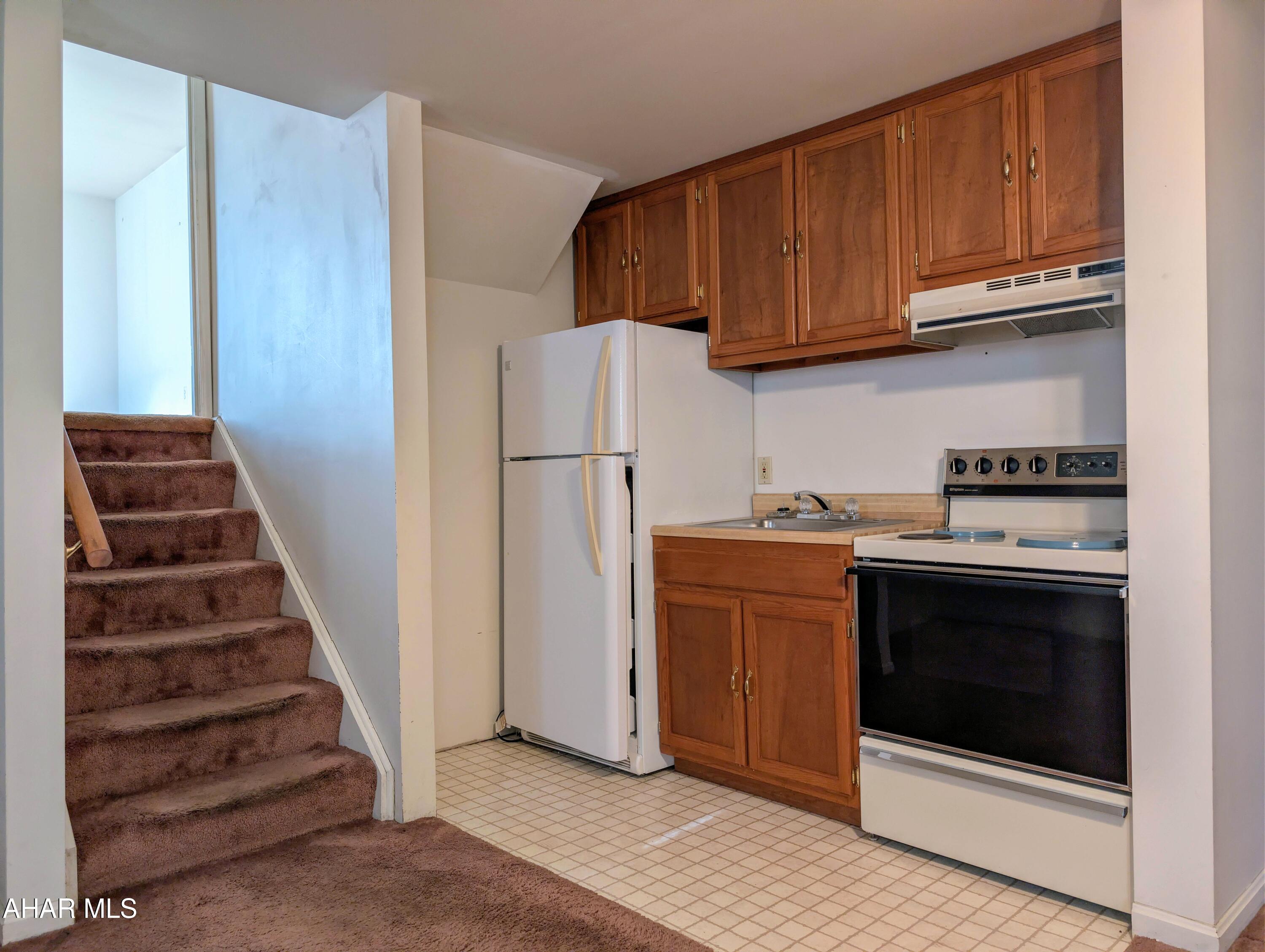 147 Pine Street Hyndman, PA 15545 - Photo 25 of 44 a kitchen with wooden cabinets and white stove