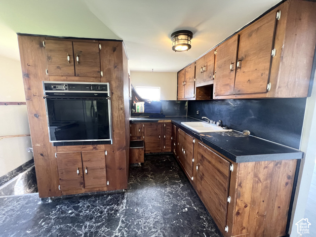 265 Roosevelt Street Helper, UT 84526 - Photo 14 of 27 Built-in wall oven, wood-finish cabinetry, dark countertops, and a single-basin sink