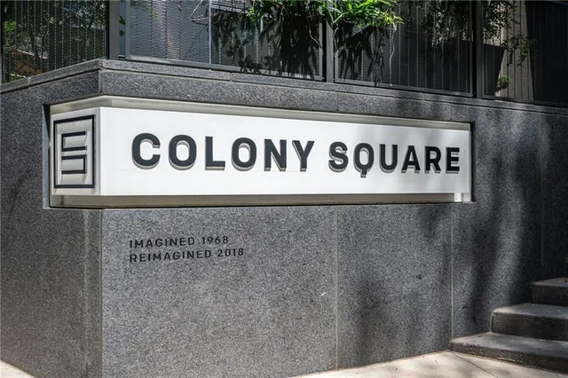 a sign board with building in the background