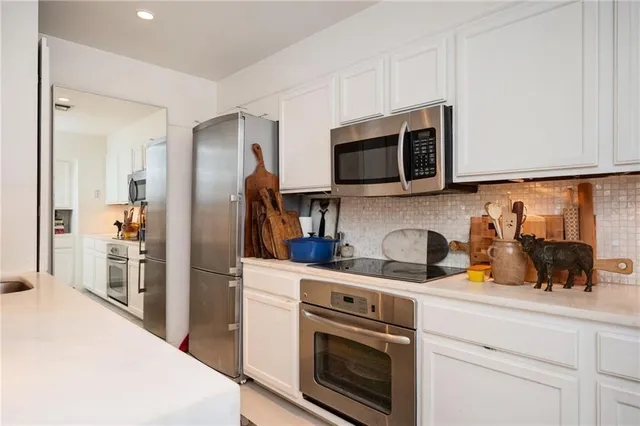a kitchen with stainless steel appliances granite countertop a stove a microwave and a refrigerator