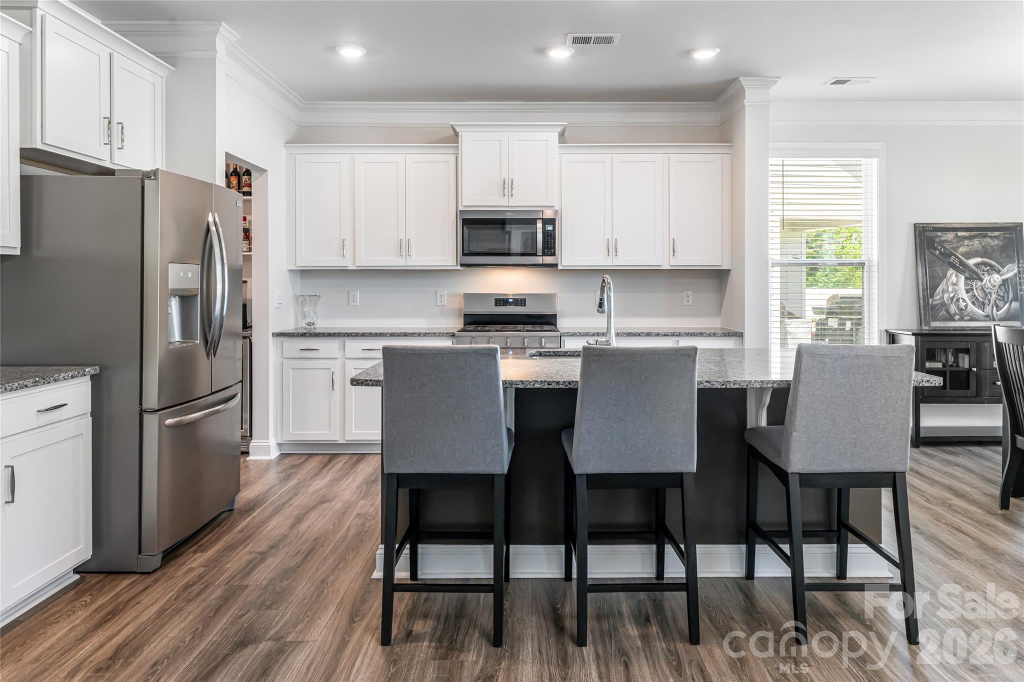 615 Fox Cove Road Hendersonville, NC 28792 - Photo 3 of 47 a kitchen with stainless steel appliances granite countertop a dining table chairs refrigerator microwave and sink