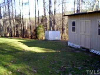 private back yard with storage shed - one on left conveys with home. Other