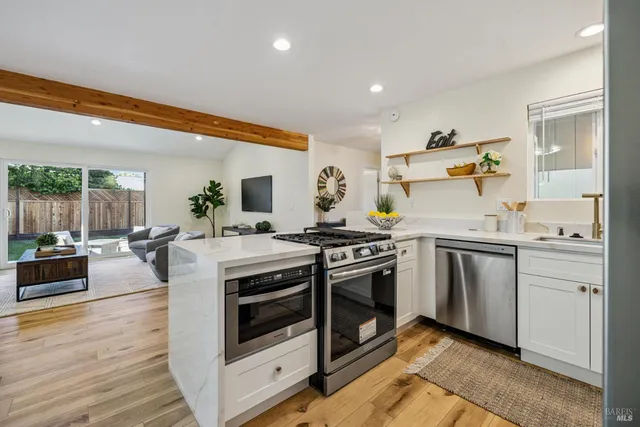 a dining room with wooden floor a chandelier a wooden table and chairs