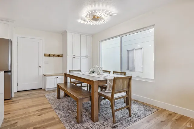 a dining area with stainless steel appliances kitchen island granite countertop a dining table chairs and granite counter tops