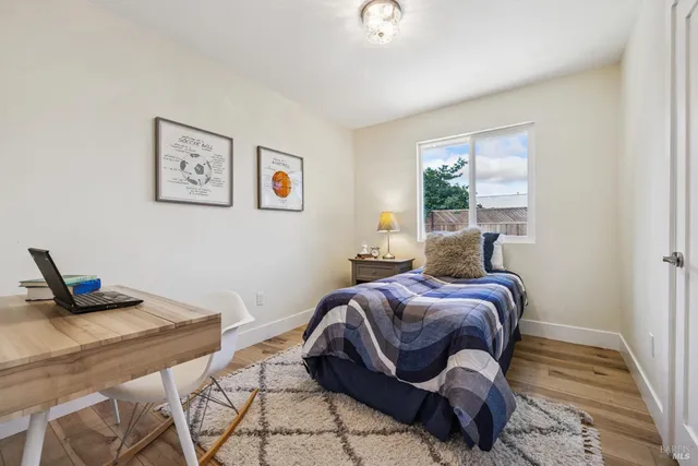 a bed sitting in a bedroom next to a window