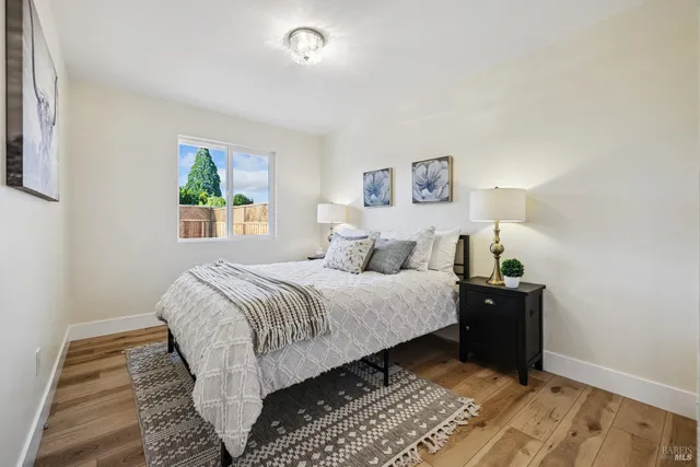 a bedroom with a bed and a painting on the wall