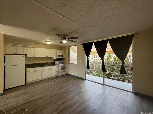 a open kitchen with white cabinets and wooden floor