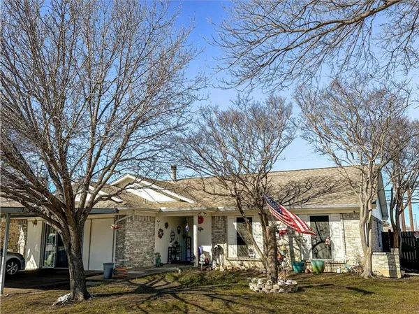 a front view of a building with large trees